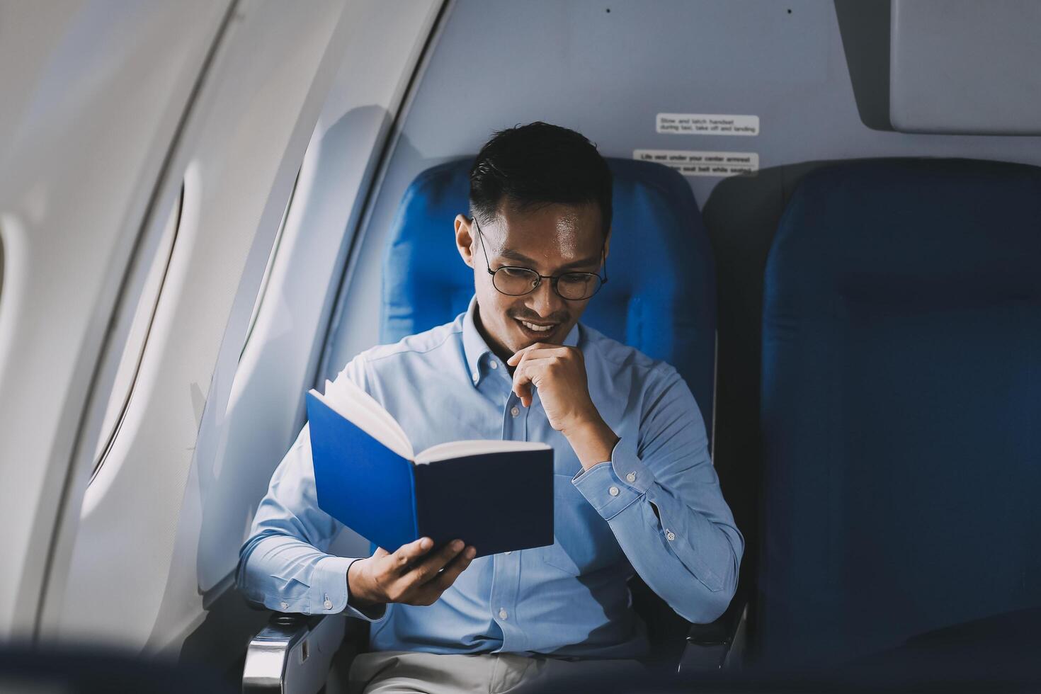 Airplane, travel and portrait of businessman working on laptop computer and smartphone while sitting in airplane. photo