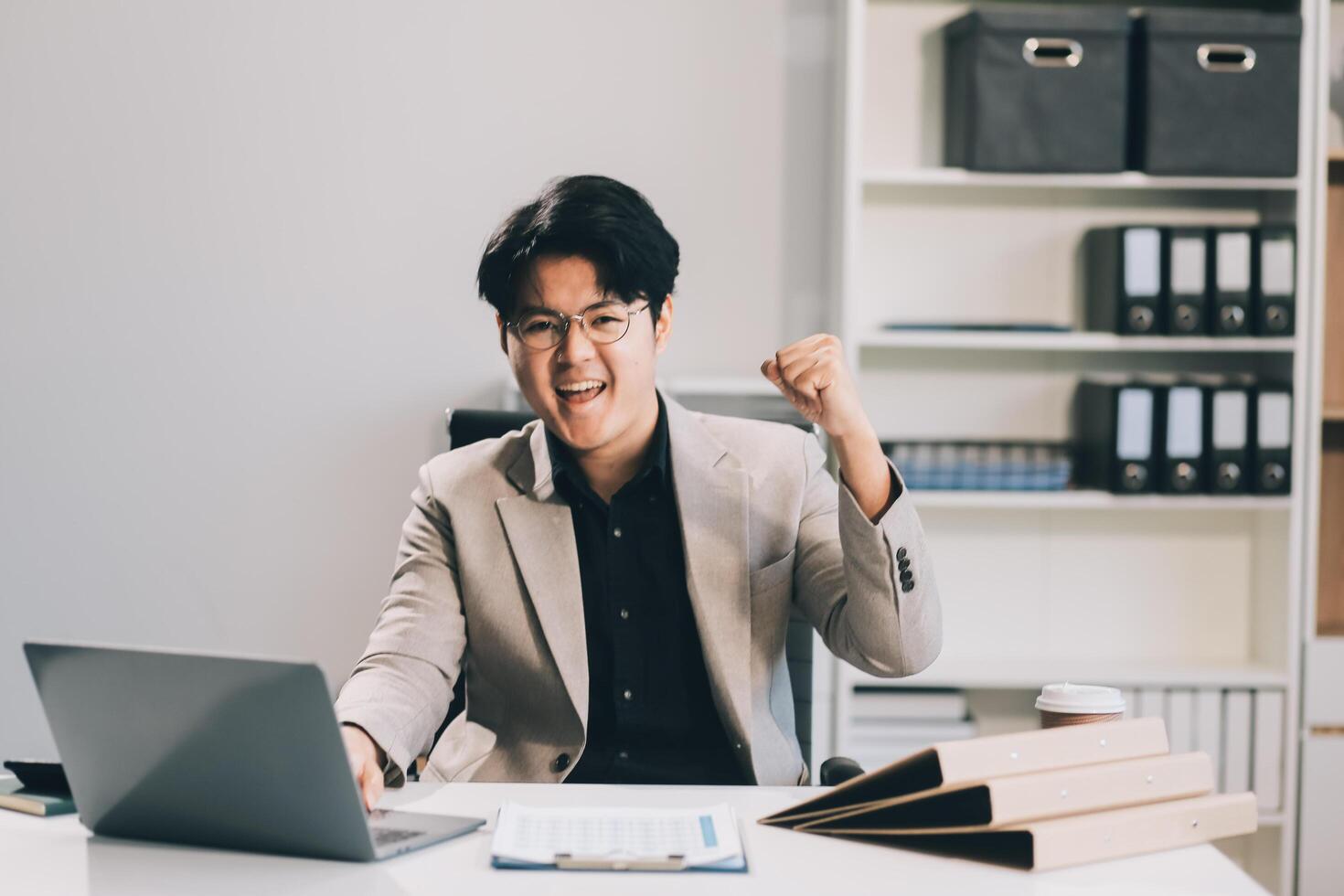 call online meeting asian businessman looking web camera and having fun talking and gesturing, man working inside office sharing plans with partners and colleagues, boss in shirt and glasses. photo