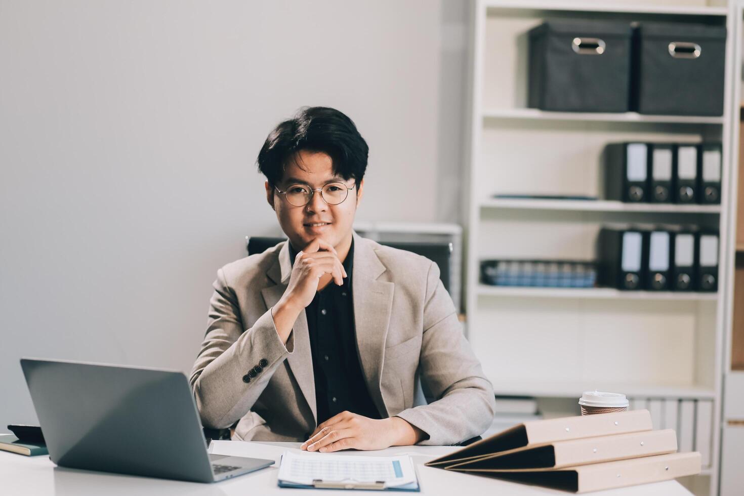 call online meeting asian businessman looking web camera and having fun talking and gesturing, man working inside office sharing plans with partners and colleagues, boss in shirt and glasses. photo