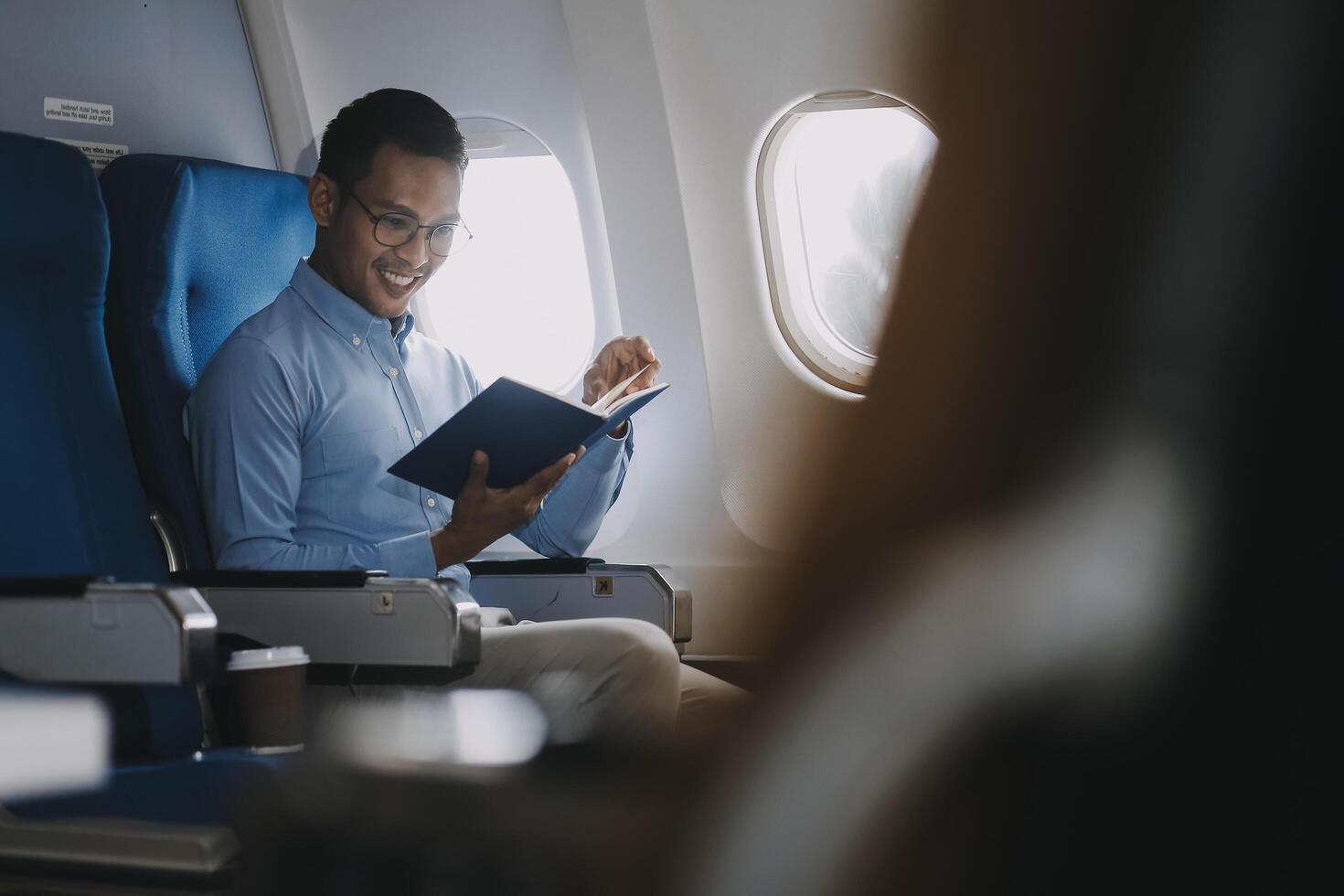 Airplane, travel and portrait of businessman working on laptop computer and smartphone while sitting in airplane. photo