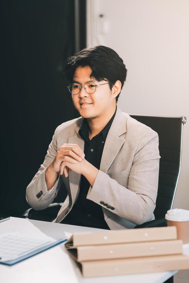 call online meeting asian businessman looking web camera and having fun talking and gesturing, man working inside office sharing plans with partners and colleagues, boss in shirt and glasses. photo