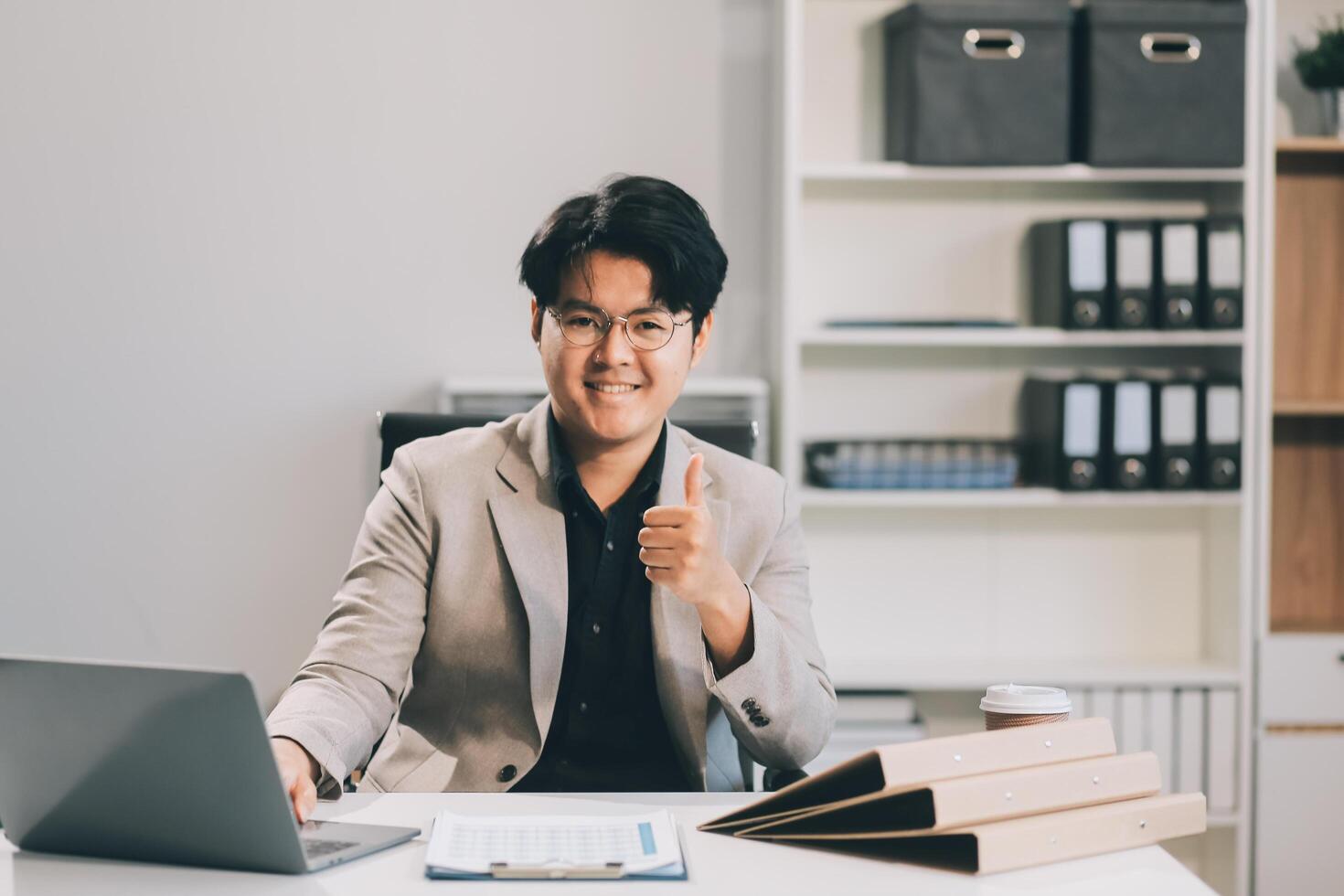 call online meeting asian businessman looking web camera and having fun talking and gesturing, man working inside office sharing plans with partners and colleagues, boss in shirt and glasses. photo
