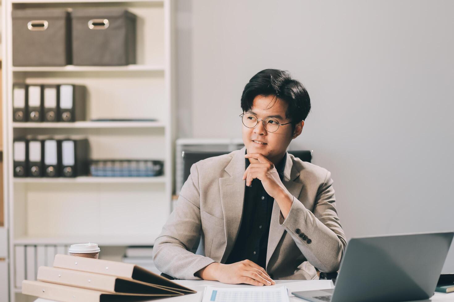 call online meeting asian businessman looking web camera and having fun talking and gesturing, man working inside office sharing plans with partners and colleagues, boss in shirt and glasses. photo