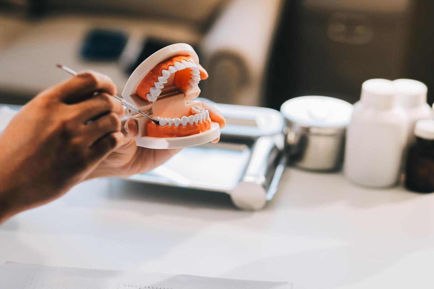 A dentist is using specialized dental equipment to inspect dentures to study the anatomy of the teeth before using the knowledge to treat patients, Dentures are being studied by oral specialists. photo