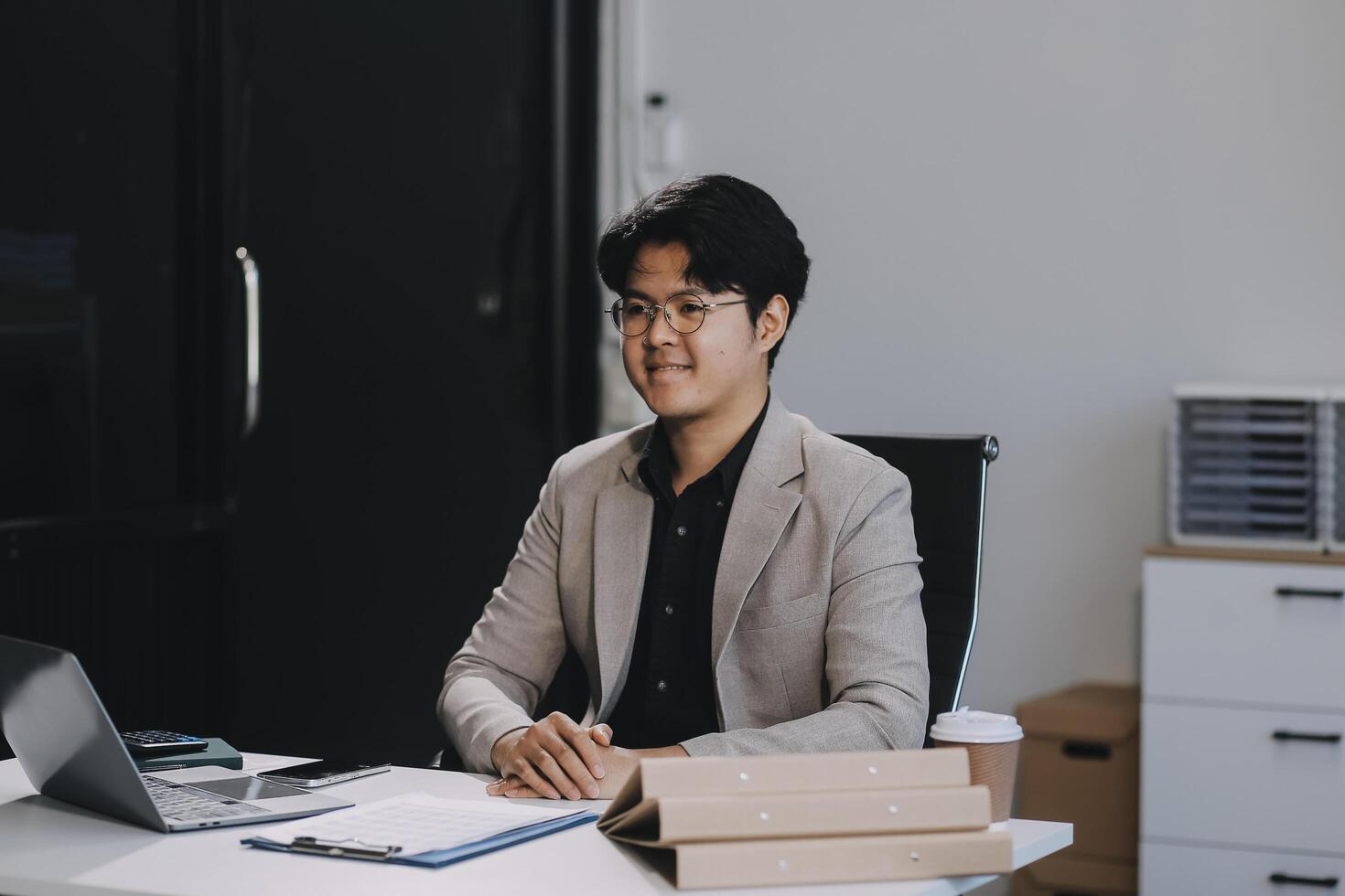 call online meeting asian businessman looking web camera and having fun talking and gesturing, man working inside office sharing plans with partners and colleagues, boss in shirt and glasses. photo
