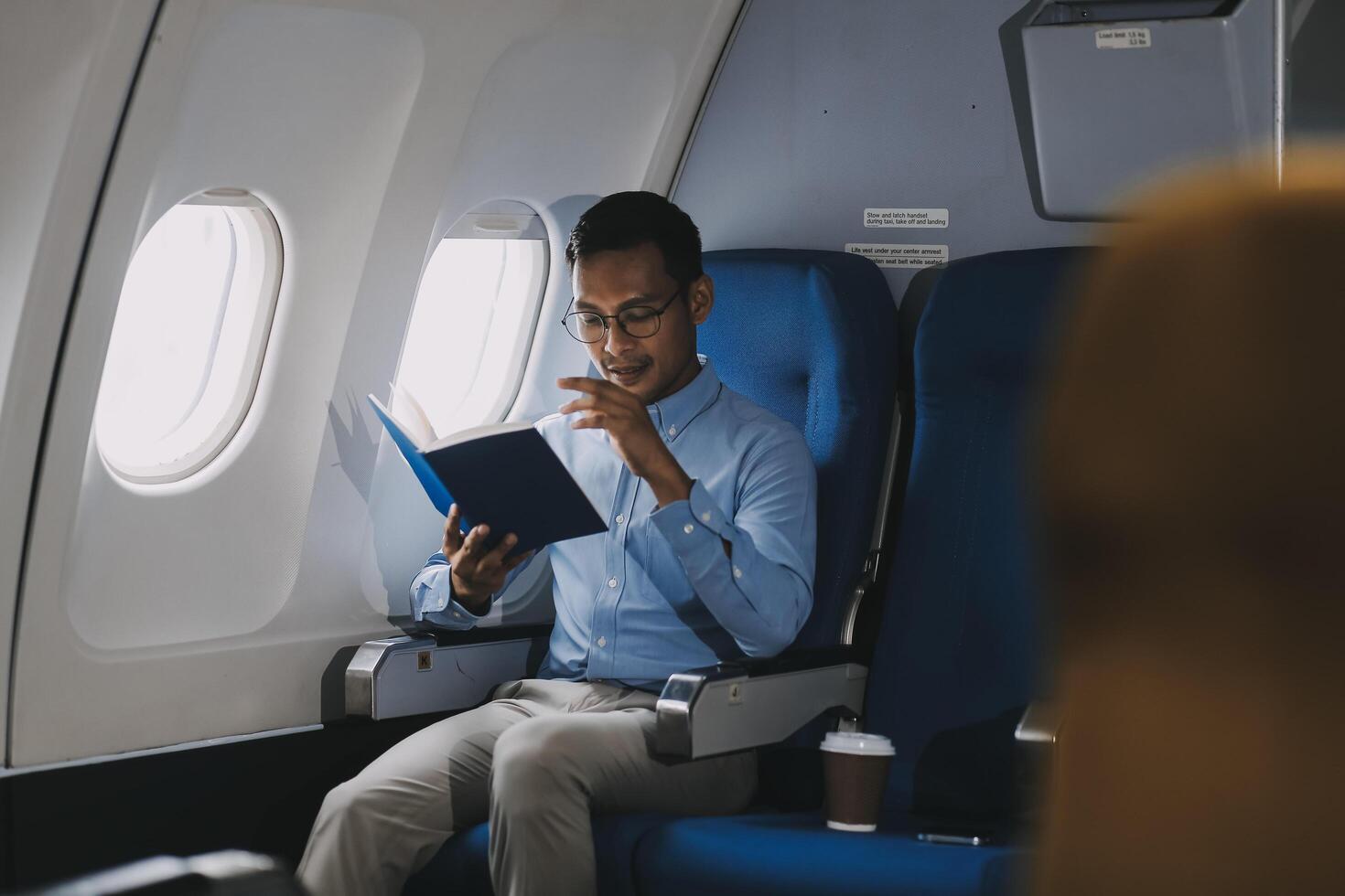 Airplane, travel and portrait of businessman working on laptop computer and smartphone while sitting in airplane. photo