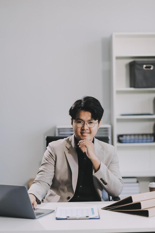 call online meeting asian businessman looking web camera and having fun talking and gesturing, man working inside office sharing plans with partners and colleagues, boss in shirt and glasses. photo