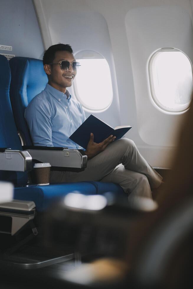 Airplane, travel and portrait of businessman working on laptop computer and smartphone while sitting in airplane. photo