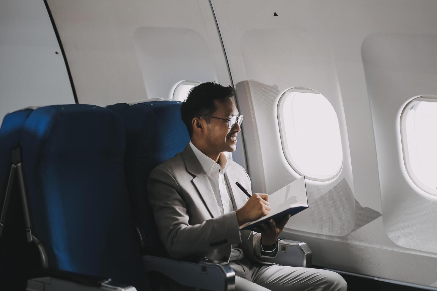 Airplane, travel and portrait of businessman working on laptop computer and smartphone while sitting in airplane. photo