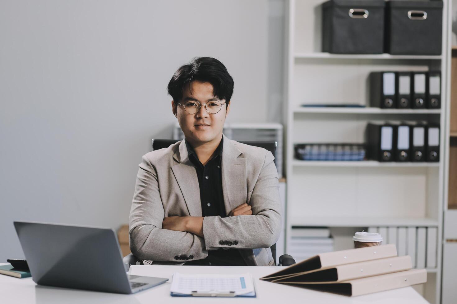 call online meeting asian businessman looking web camera and having fun talking and gesturing, man working inside office sharing plans with partners and colleagues, boss in shirt and glasses. photo