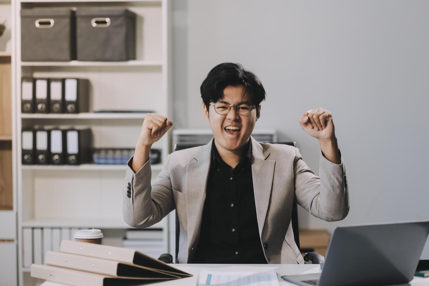 call online meeting asian businessman looking web camera and having fun talking and gesturing, man working inside office sharing plans with partners and colleagues, boss in shirt and glasses. photo
