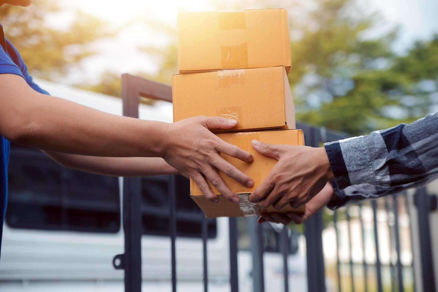 Asian delivery express courier young man use giving boxes to woman customer he wearing protective face mask at front home photo