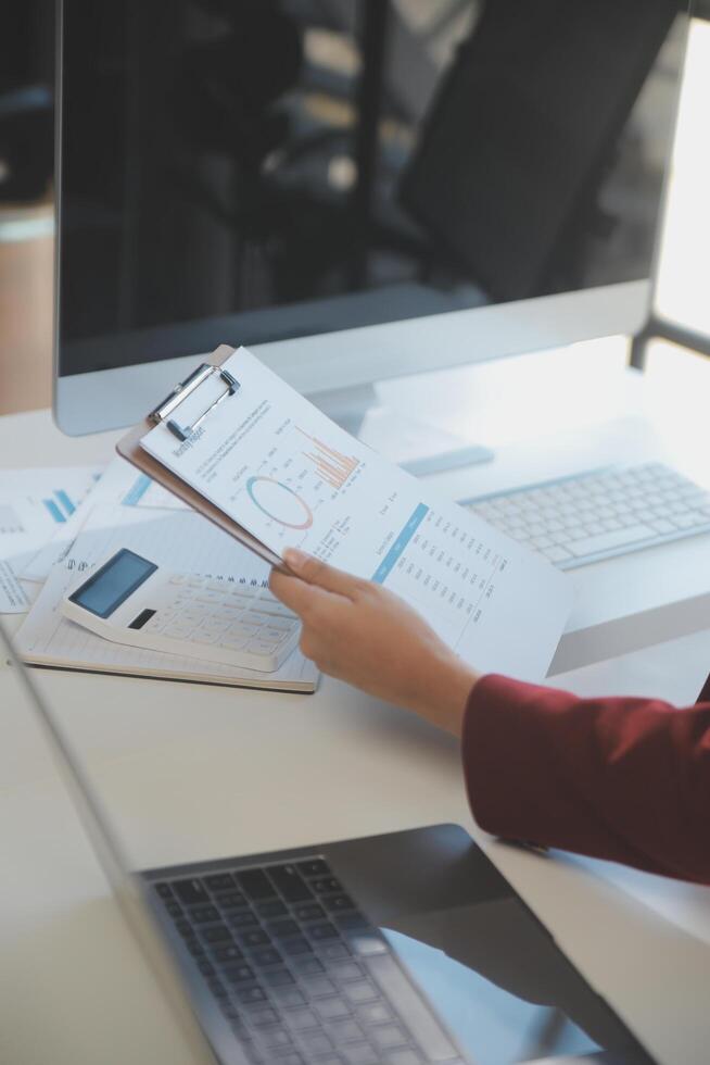 Cropped image of professional businesswoman working at her office via laptop, young female manager using portable computer device while sitting at modern loft, flare light, work process concept photo