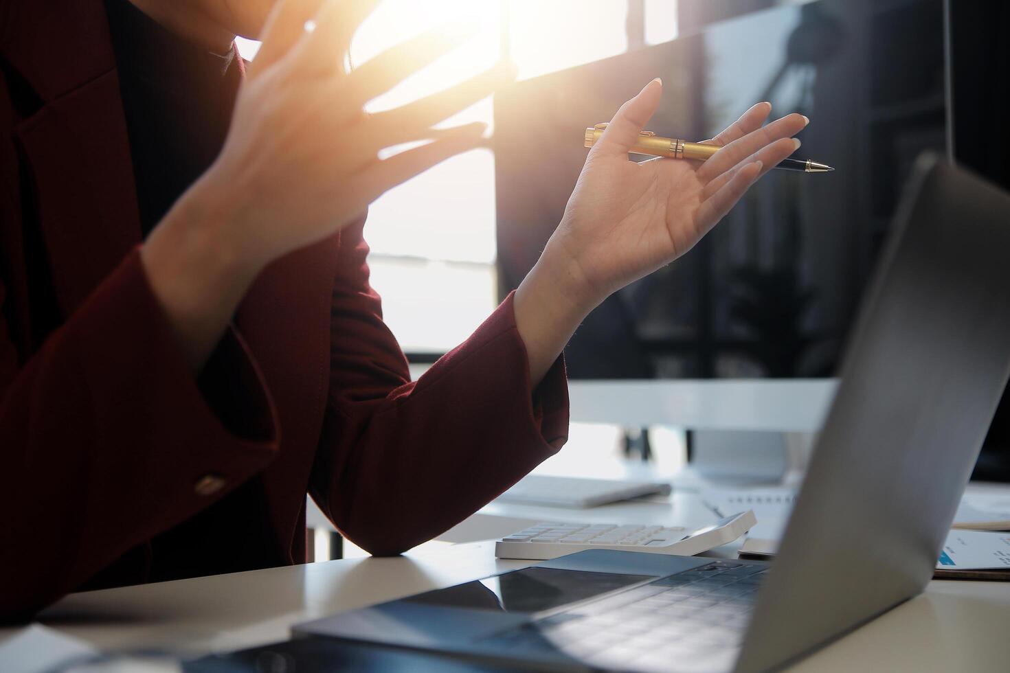 Cropped image of professional businesswoman working at her office via laptop, young female manager using portable computer device while sitting at modern loft, flare light, work process concept photo
