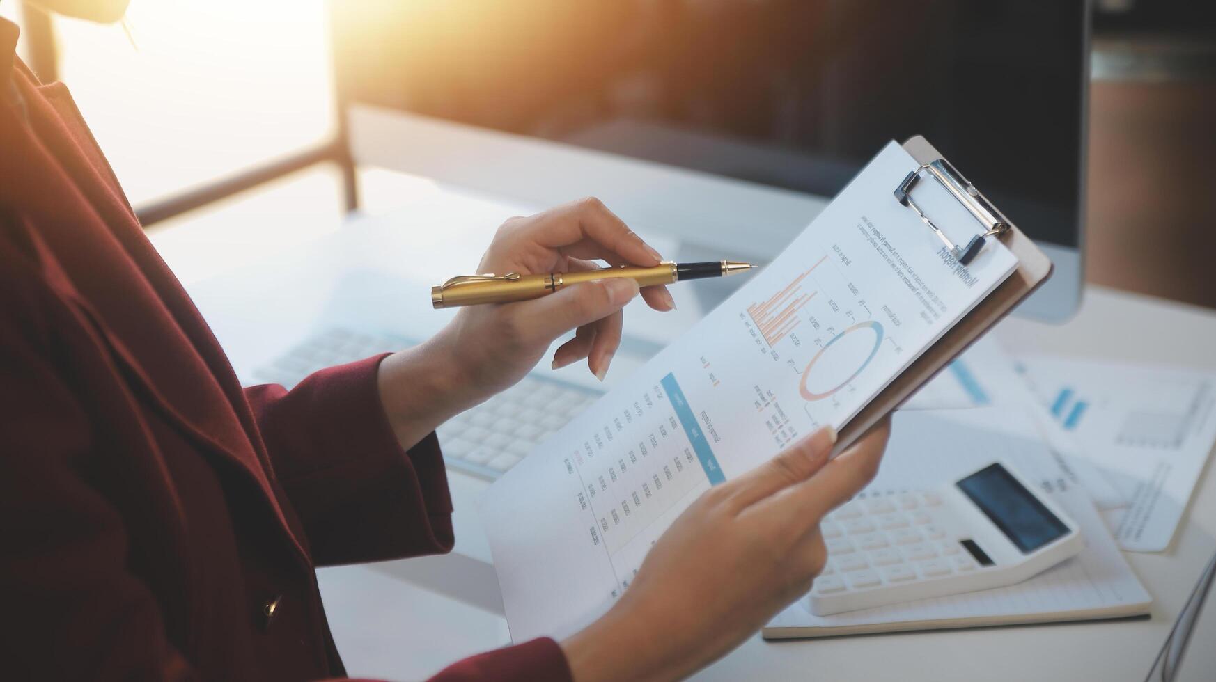 Cropped image of professional businesswoman working at her office via laptop, young female manager using portable computer device while sitting at modern loft, flare light, work process concept photo