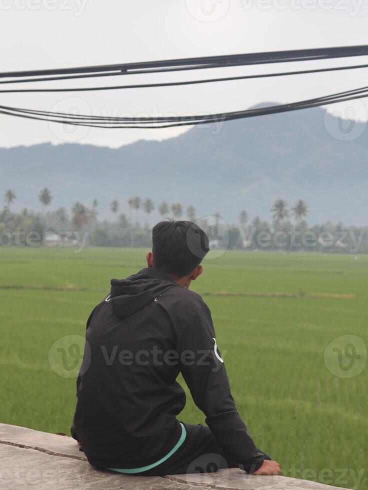 A man looking at the rice fields from the top of the hill photo