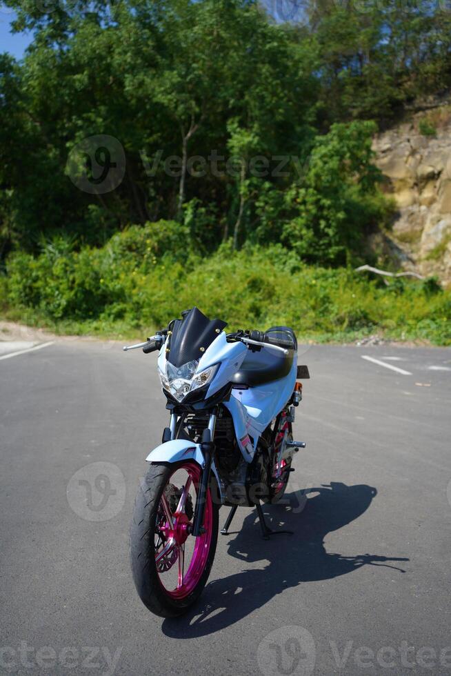 4-Stroke underbone category motorbike that has been modified with a more attractive color than the original. photo