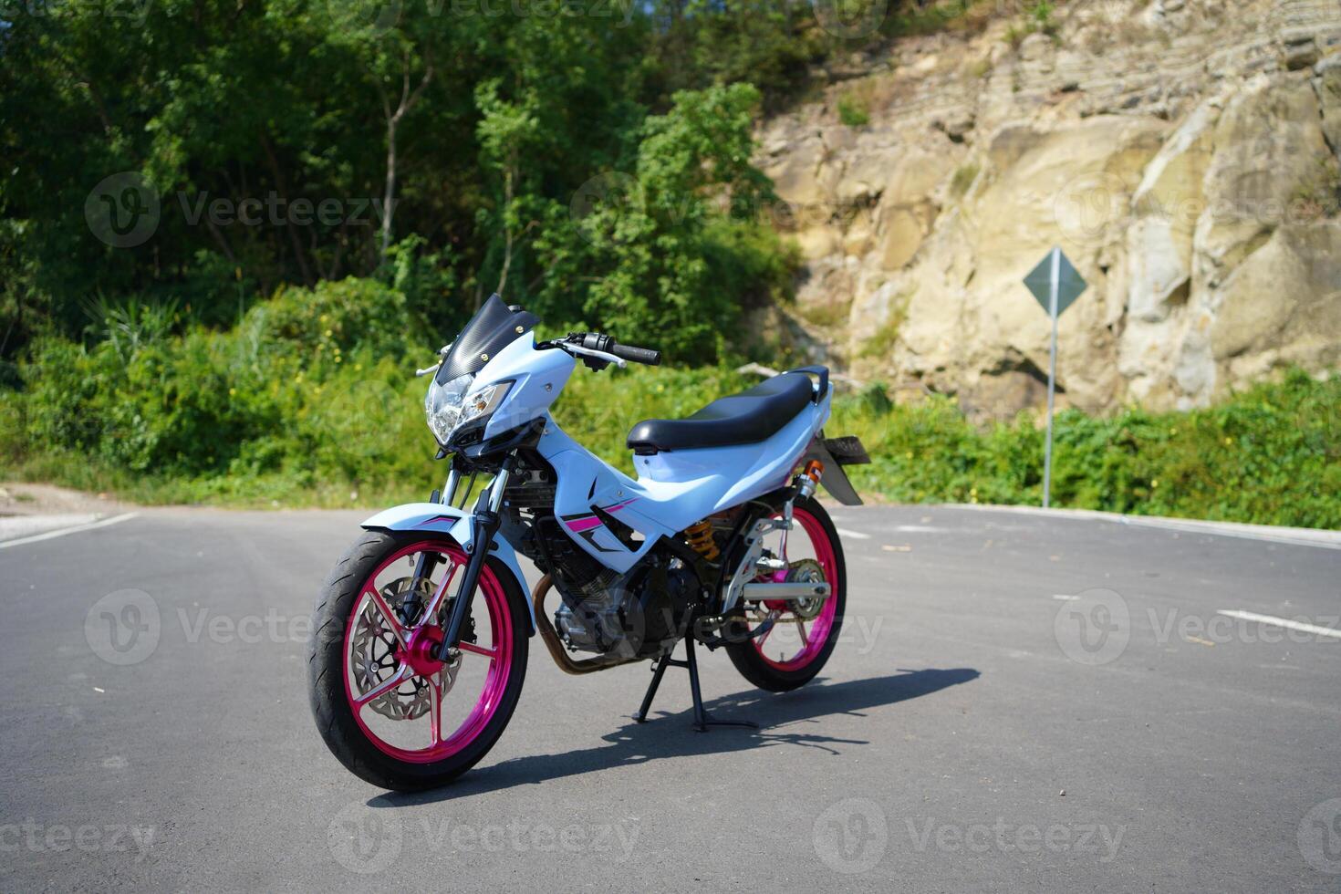 4-Stroke underbone category motorbike that has been modified with a more attractive color than the original. photo