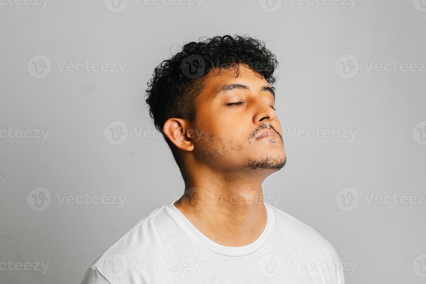 Young man standing in a studio, showing his beautiful skin photo