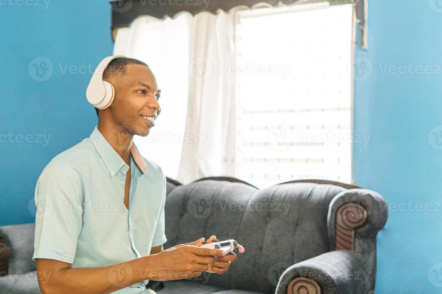 Smiling men playing in games on tv at home. Young black man with joysticks play game. photo