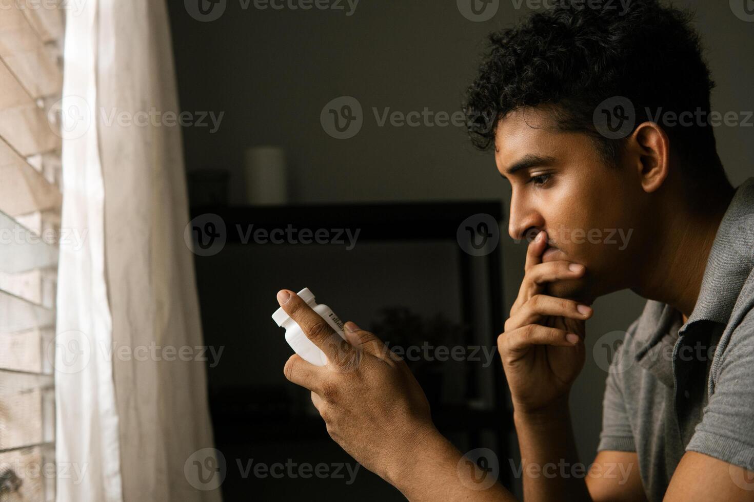 Adult man holding and looking at a bottle of pills. concept mental health and antidepressants. photo