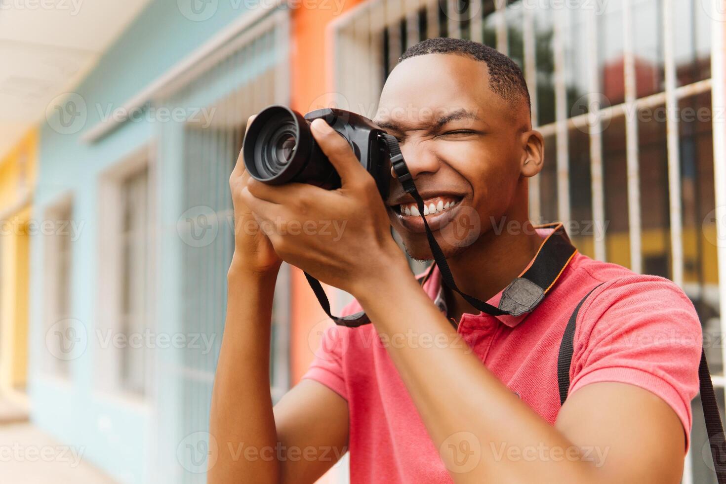 Young stylish male photographer using camera while exploring the city. Photographer world day concept. photo