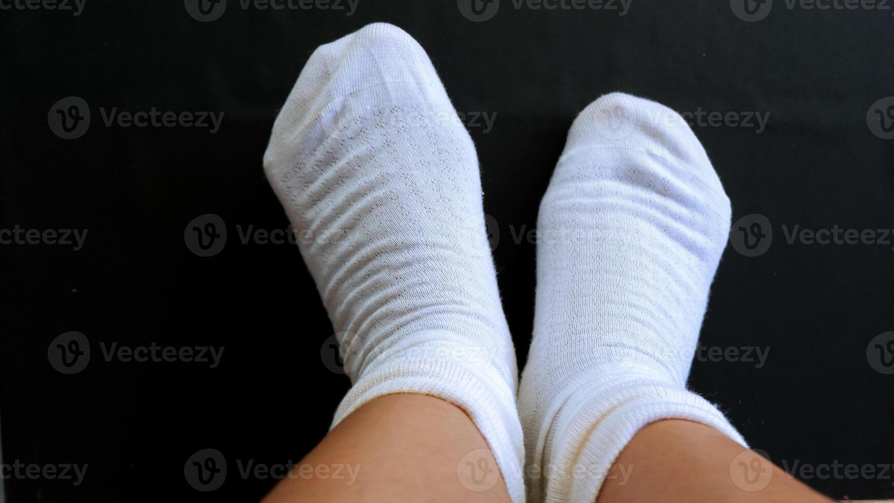 closeup feet wearing socks over black background photo