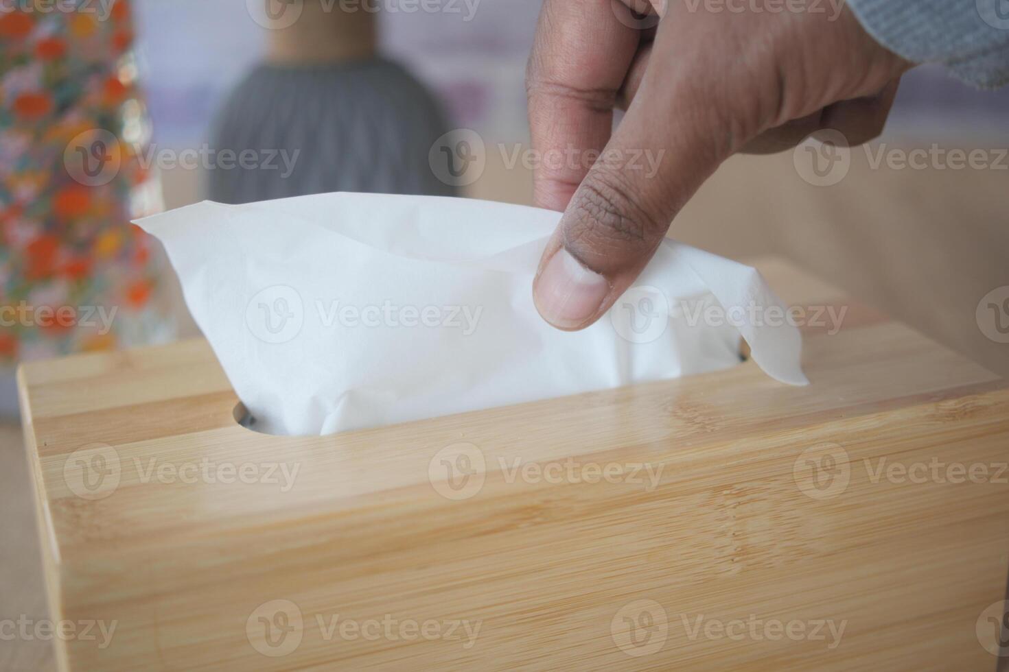 hand pull out a piece of tissue from tissue paper box photo