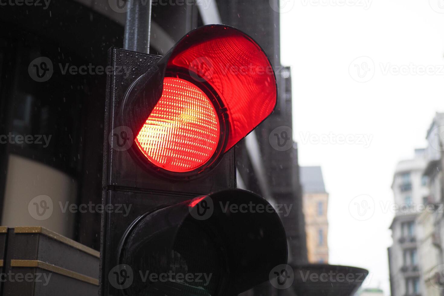 Red Traffic Light Signal on City Street, Stop Sign with Urban Building Background photo