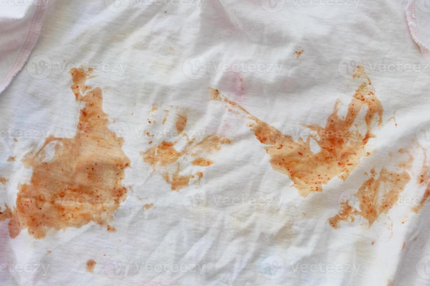 A white fabric stained with tomato sauce requires a meticulous cleaning process photo