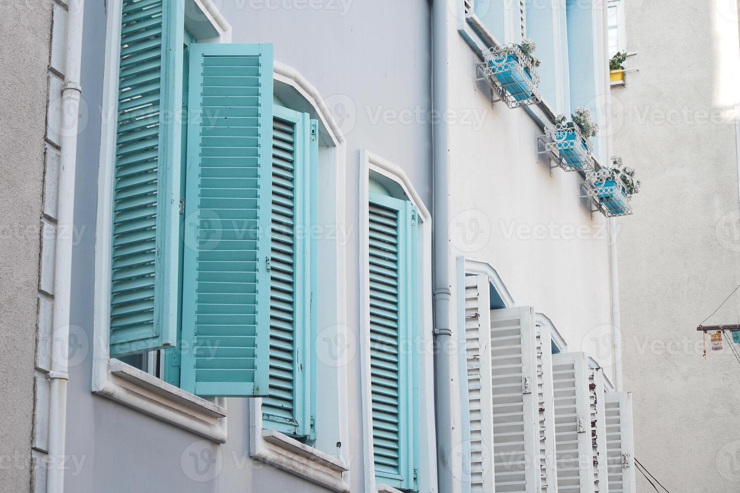Mediterraneanstyle windows with blue shutters shine on a sunny day, creating a beautiful scene photo