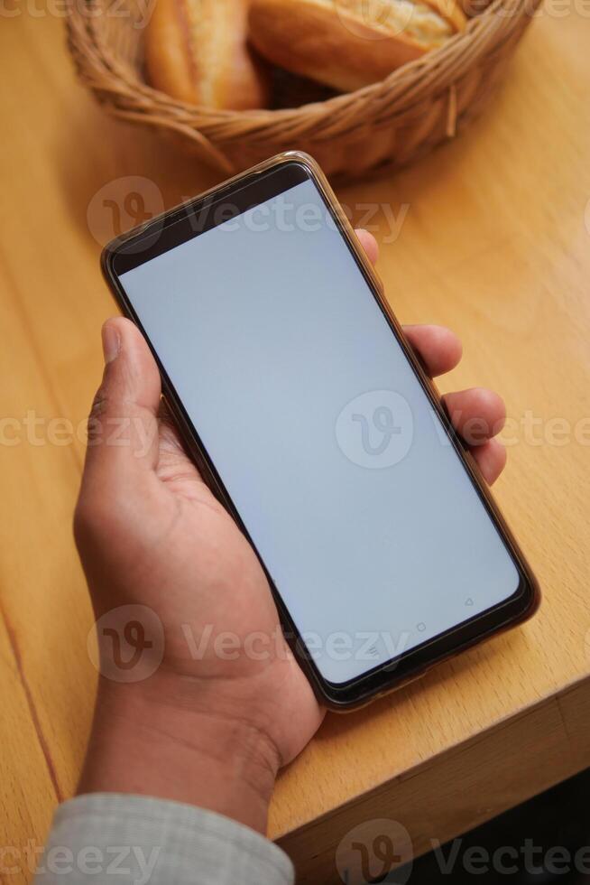 pov shot of young man hand using smart phone with white screen photo