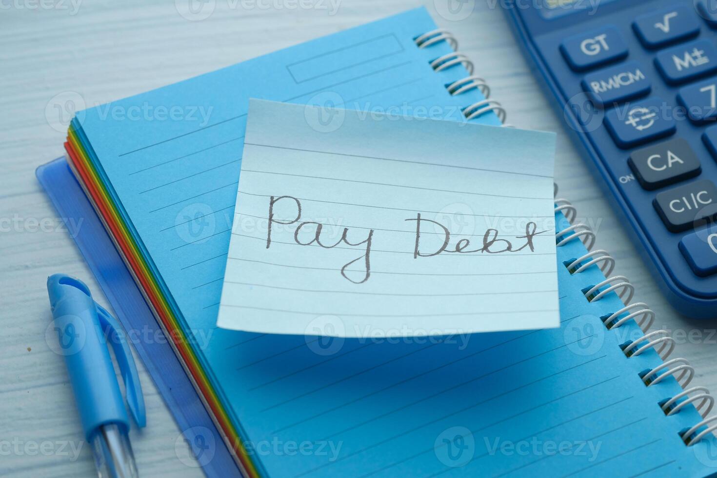 pay debt word on notepad with calculator, close up photo