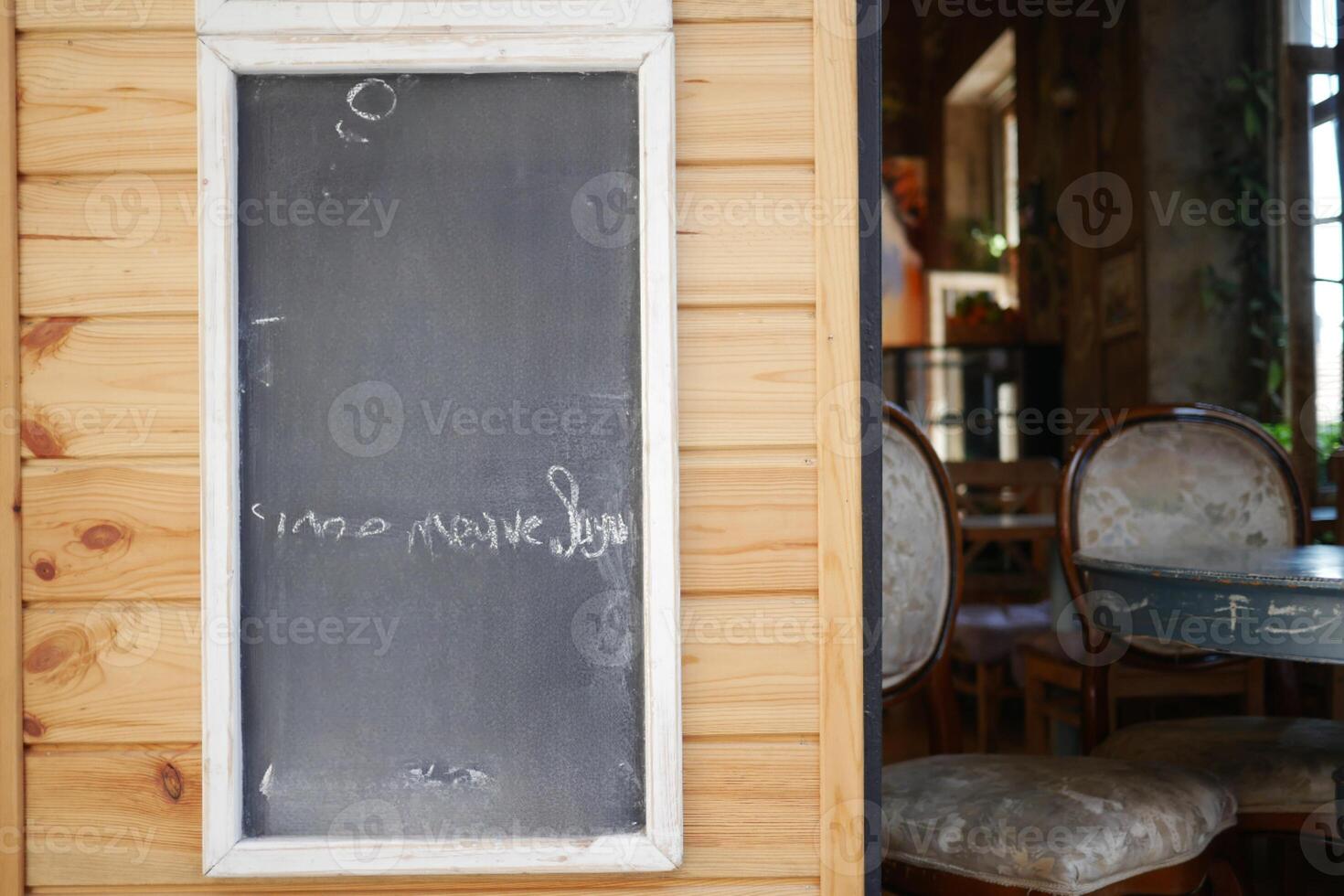 Empty wooden blackboard mockup standing outdoors in front of cafe photo