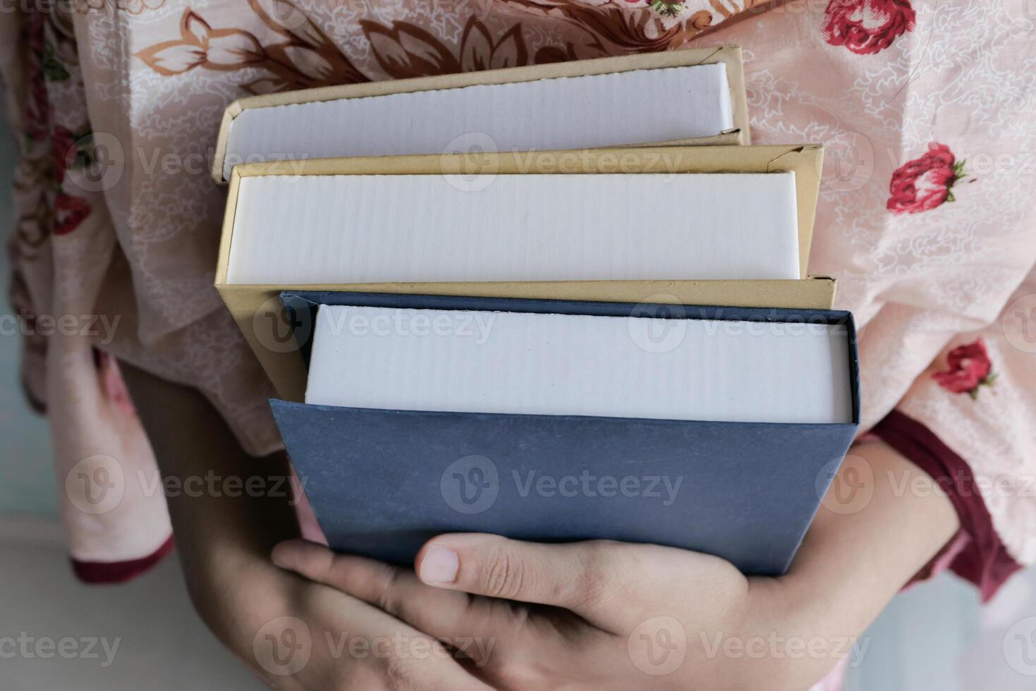 Person holding stack of books, focusing on education, literature, learning, or reading photo