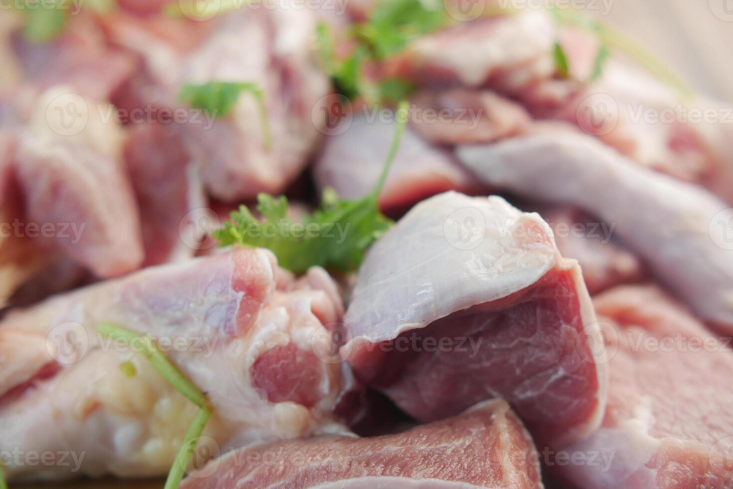 Fresh raw meat cuts displayed on a wooden board with parsley, used for cooking preparation photo