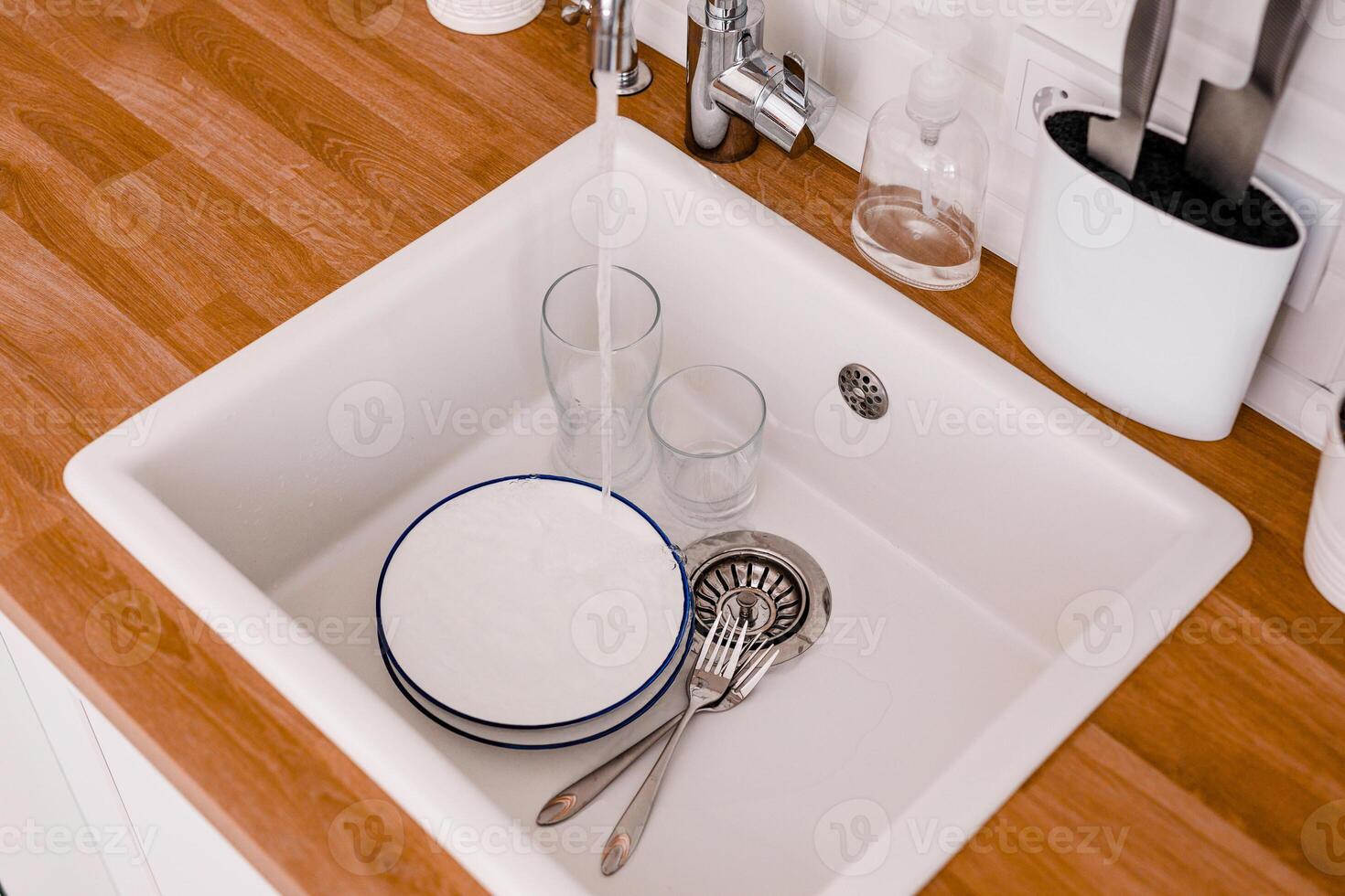 Clean white sink on wooden table in white kitchen photo