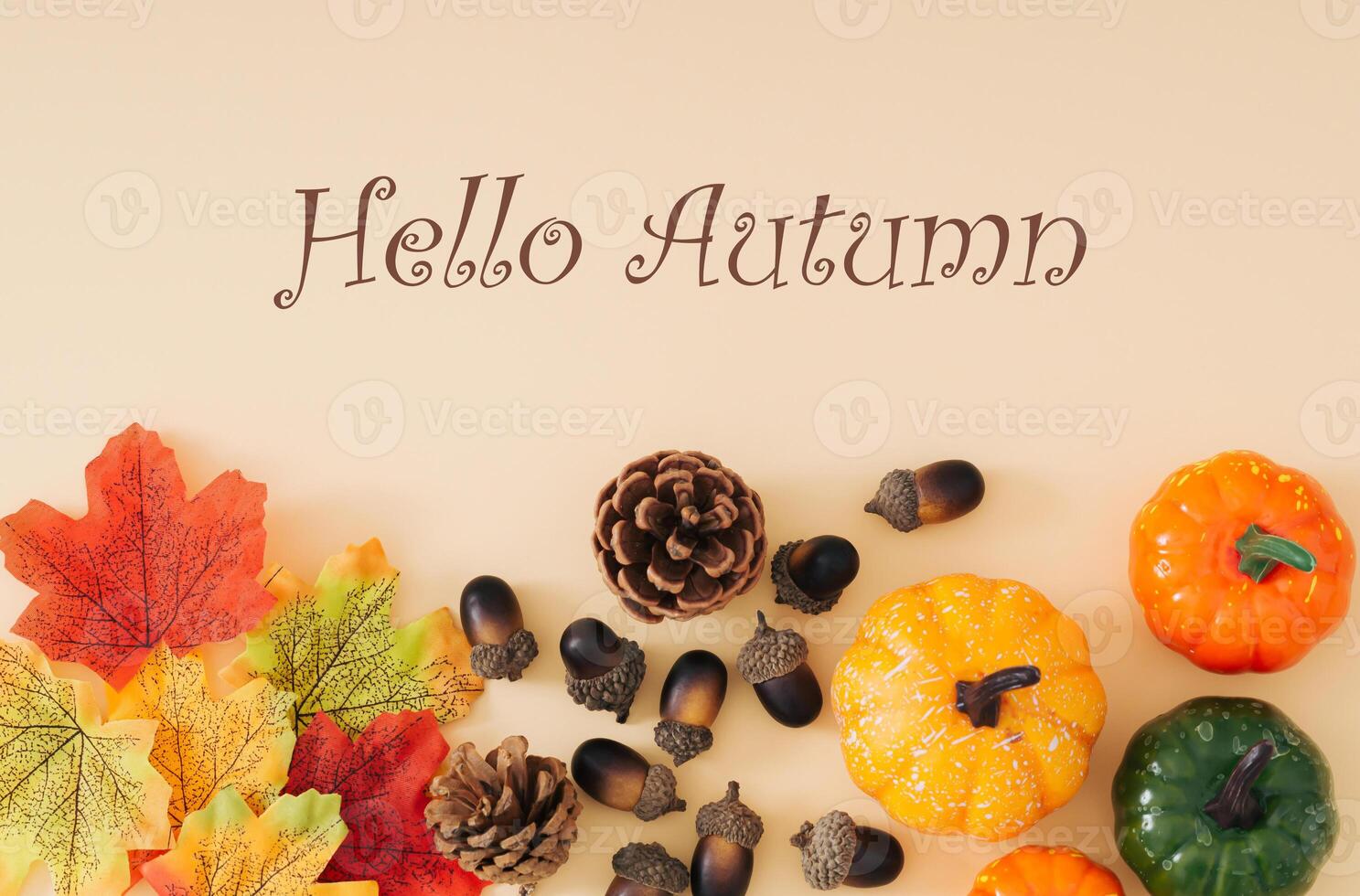 Autumn or fall scene made with colorful autumn leaves, various pumpkins, pinecones and nuts with text Hello Autumn on pastel beige background. Minimal autumn season concept. Nature flat lay. photo