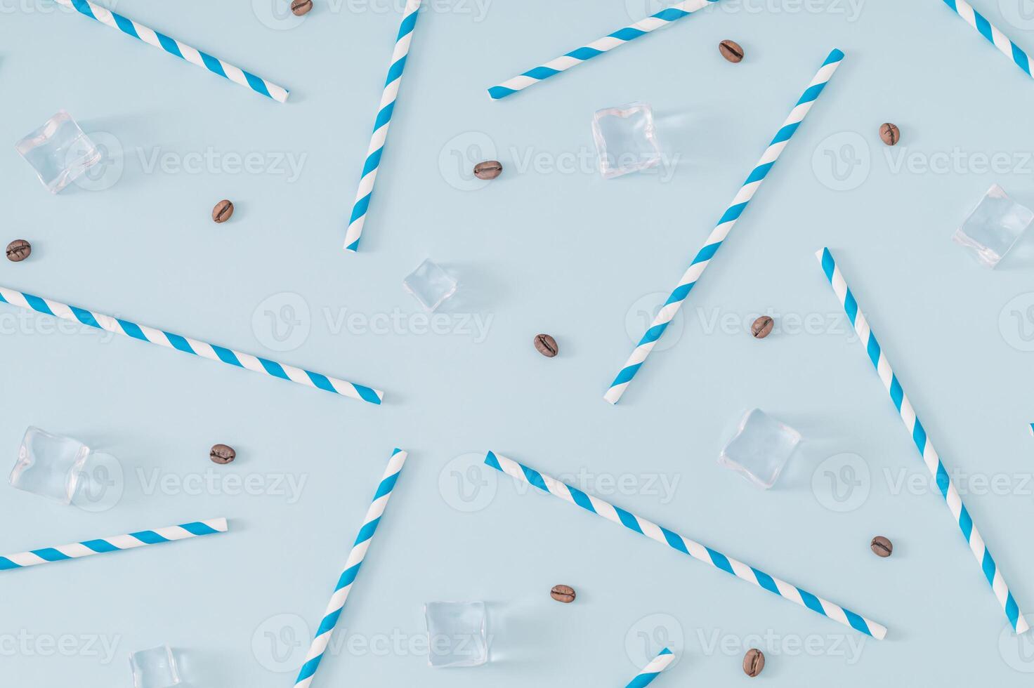 Coffee beans, ice cubes and white and blue paper drinking straws pattern on pastel blue background. Summer drink minimal concept. Flat lay composition. photo