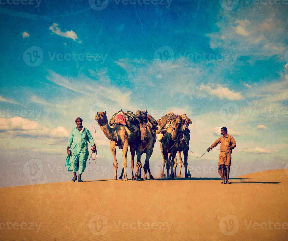 Two cameleers in dunes of Thar deser photo