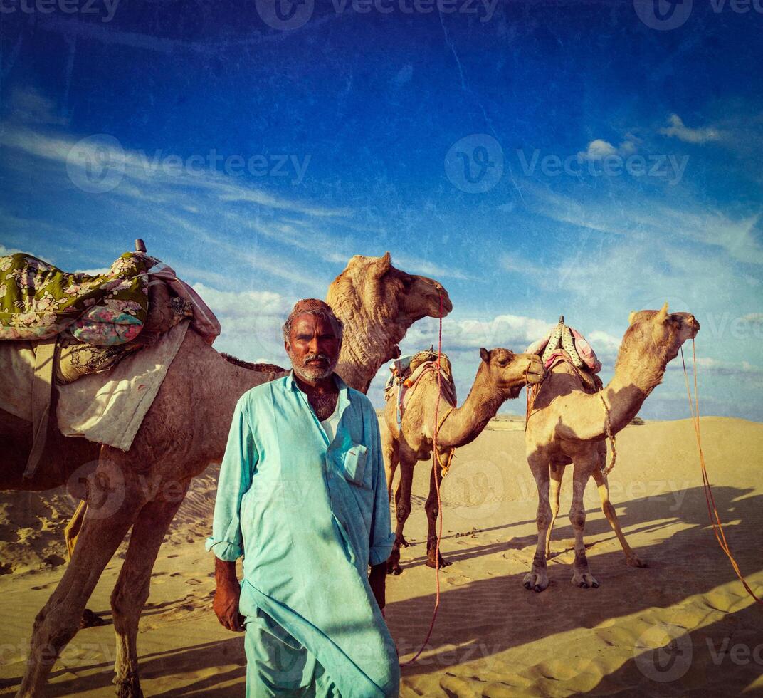 Cameleer camel driver with camels in dunes of Thar desert. Raj photo