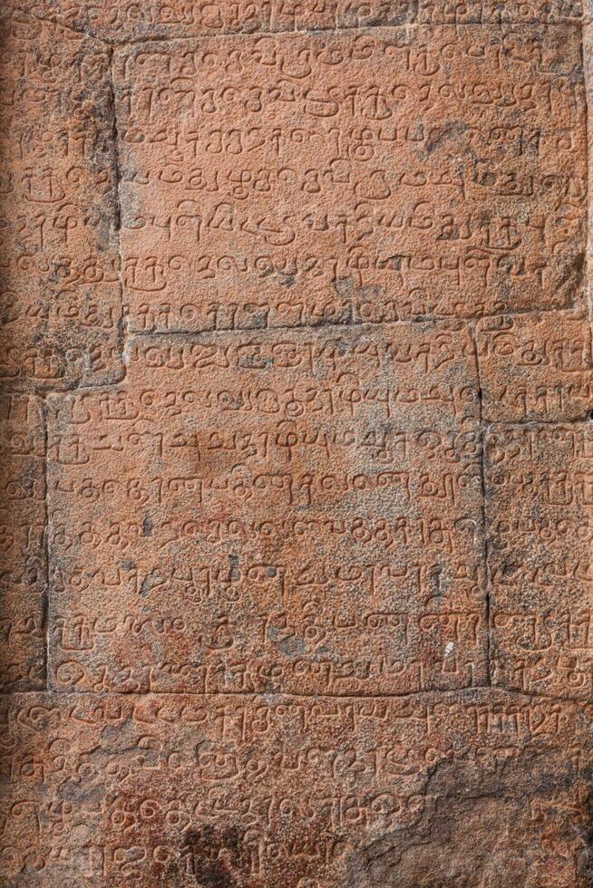 Ancient inscriptions stone wall in ancient Tamil language photo