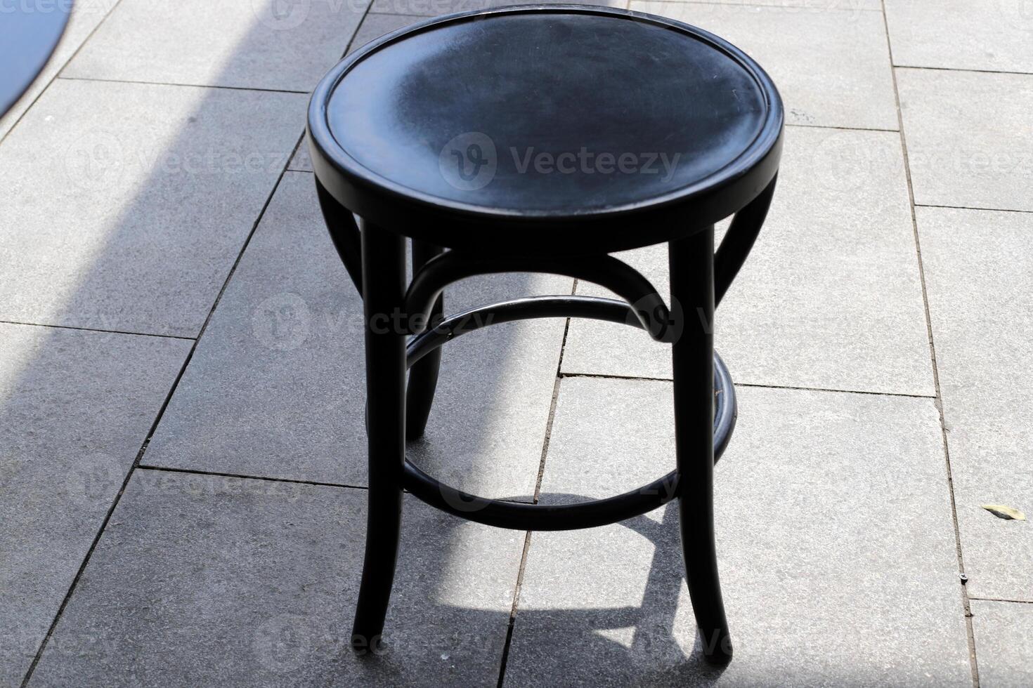 A lounge chair stands on the sidewalk on a street in a big city. photo