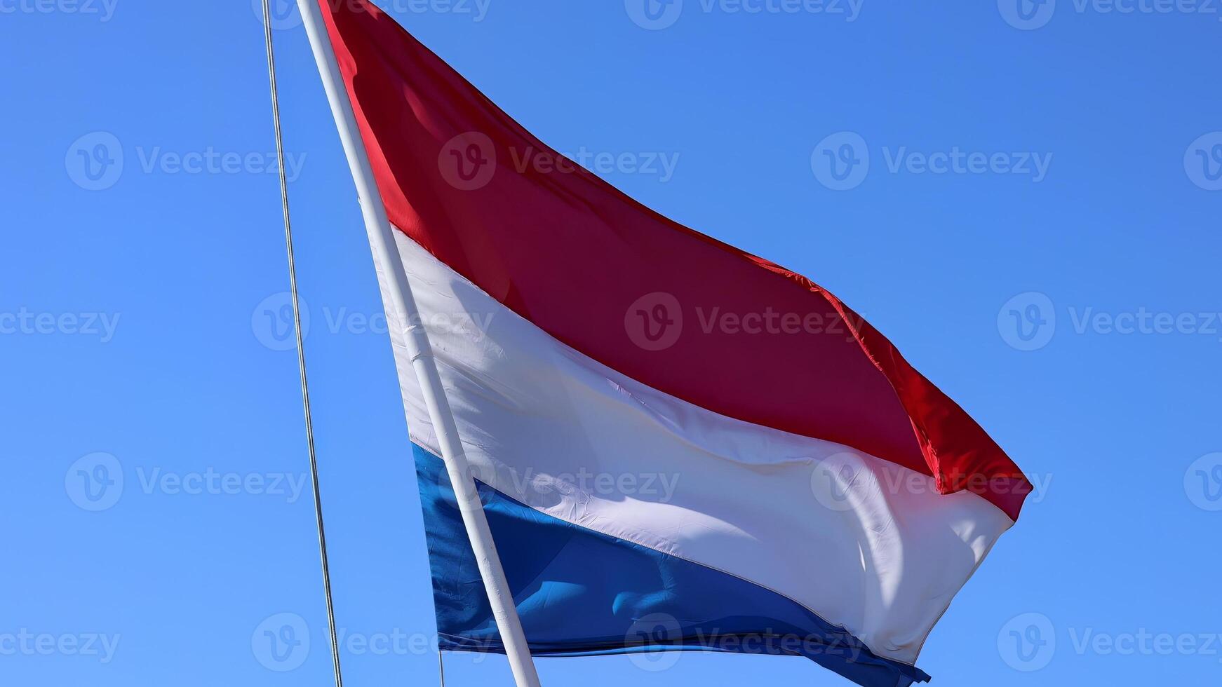 Holland Netherlands Flag proudly waving in the air with blue sky in the background photo