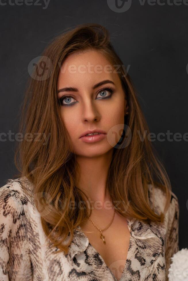 Portrait of a beautiful young business woman standing against grey background photo