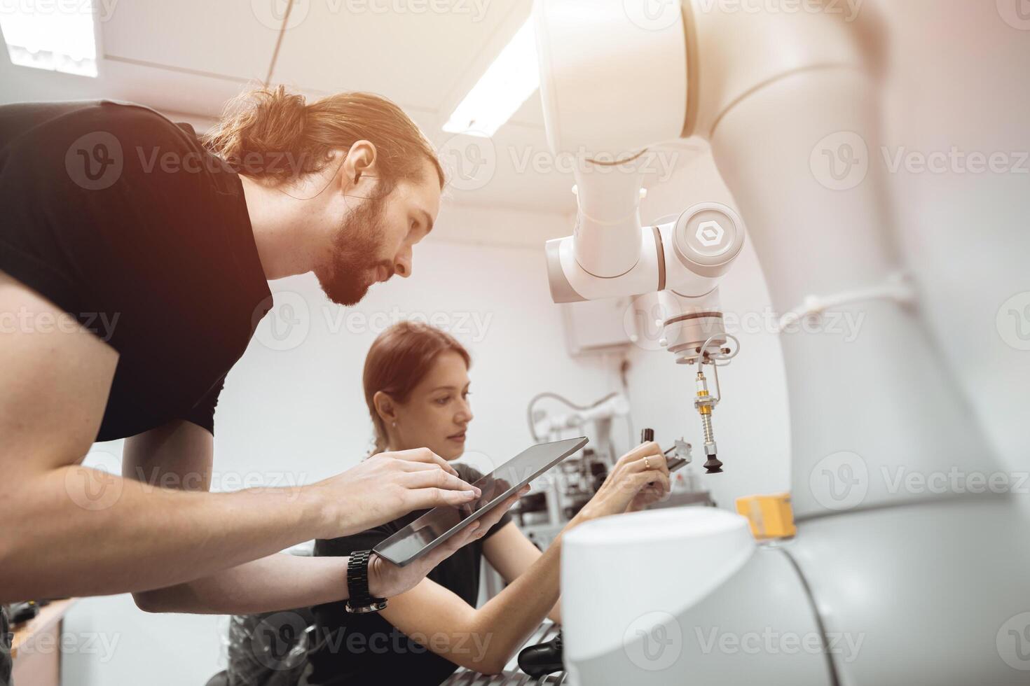 Industrial Robotics program university students learning education mechanical assembly with Robot Universal Training Platform robot arm simulation model in engineering lab classroom. photo