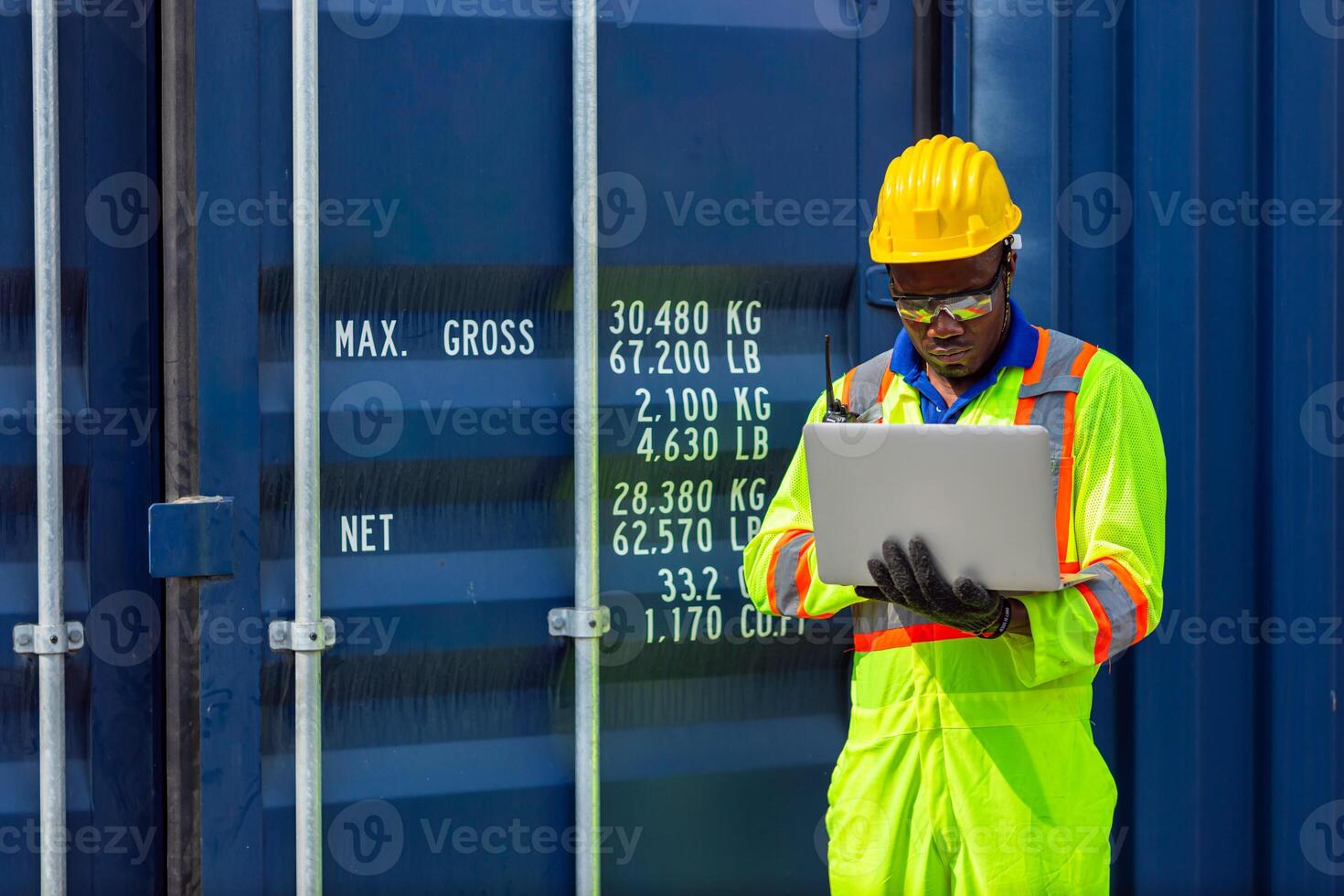 African Black Worker in Cargo Port Shipping Industrial in Yellow Hard Hat Safety Vest on Duty. Foreman or Supervisor in Container Ship Yard Terminal. photo