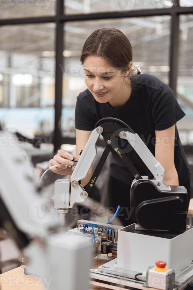 Engineer women learning education in Industrial Robotics program with robot arm simulation model in university engineering lab classroom. photo