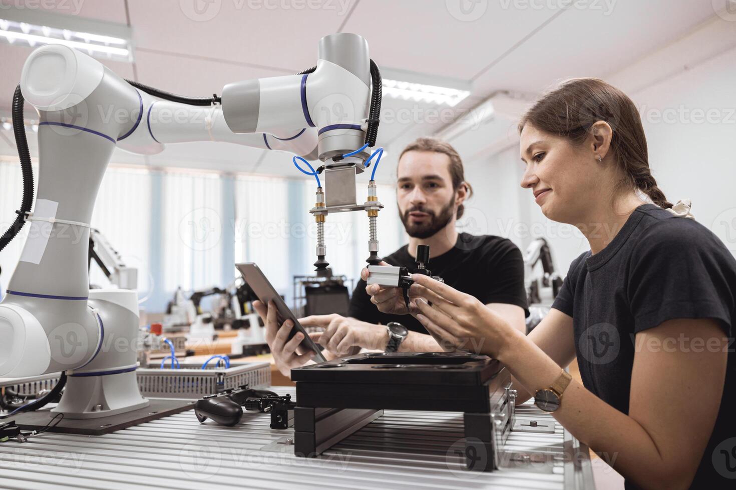 Industrial Robotics program university students learning education mechanical assembly with Robot Universal Training Platform robot arm simulation model in engineering lab classroom. photo