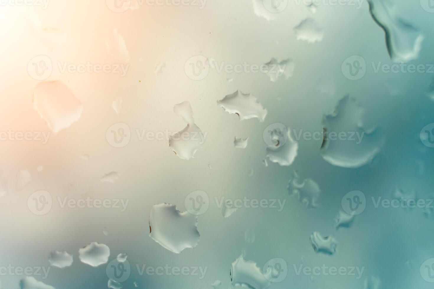 Water drops on glass against blue sky, rainy season concept. Window view background screensaver photo